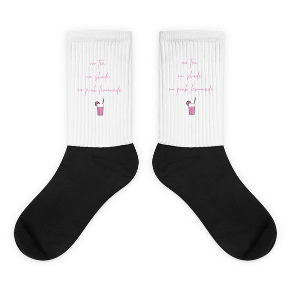 Pair of black socks with white cuffs reading “no tea, no shade, no pink lemonade”