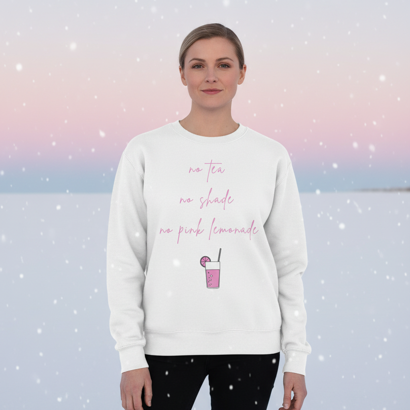 Front-facing model in a white sweatshirt reading “no tea no shade no pink lemonade” with a pink drink graphic