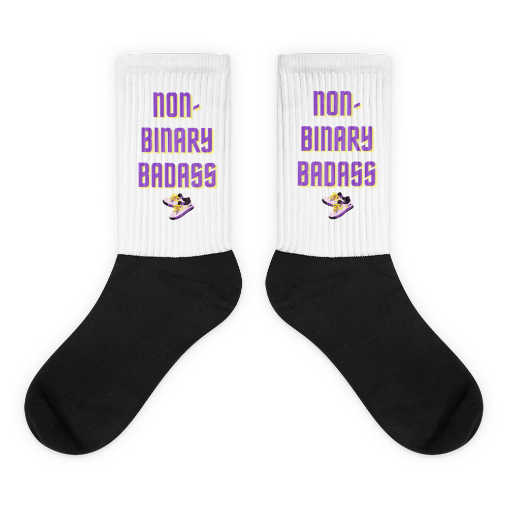 Pair of white ribbed socks with black feet and “NON-BINARY BADASS” lettering