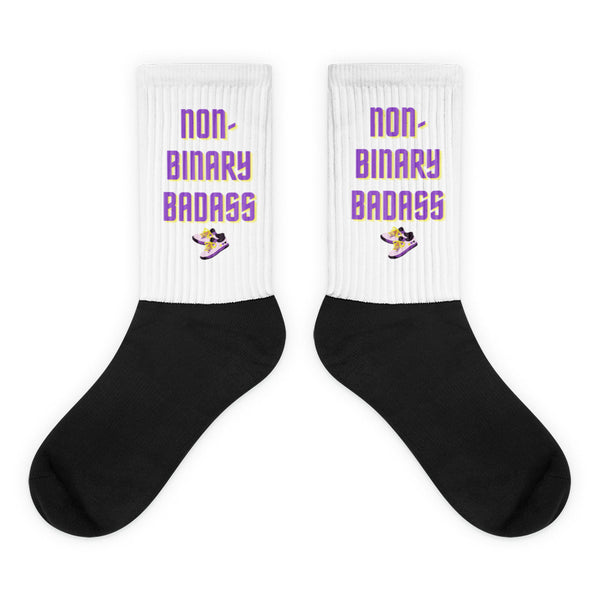 Pair of white ribbed socks with black feet and “NON-BINARY BADASS” lettering