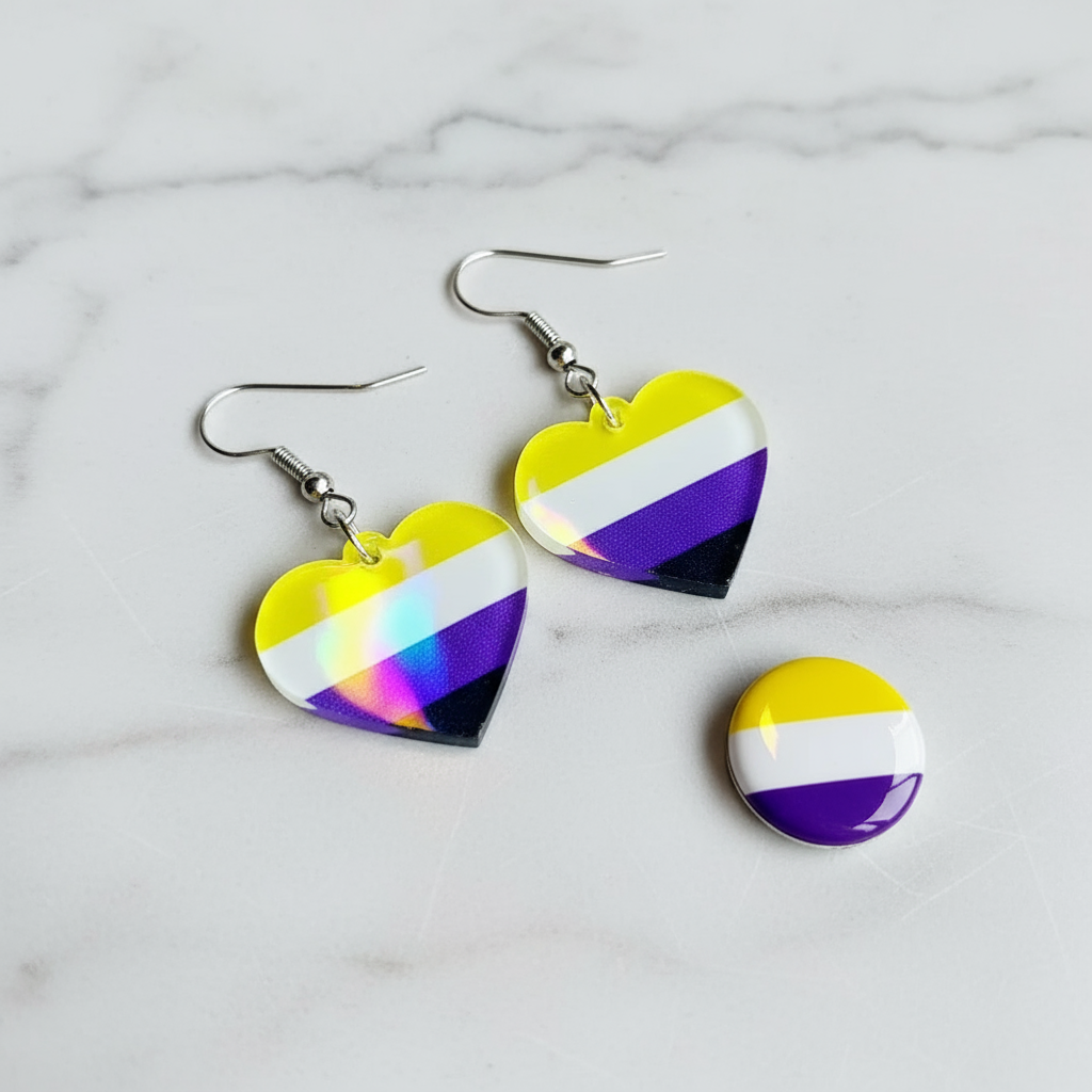 Two heart-shaped yellow, white, purple, and black dangle earrings beside a matching round pin