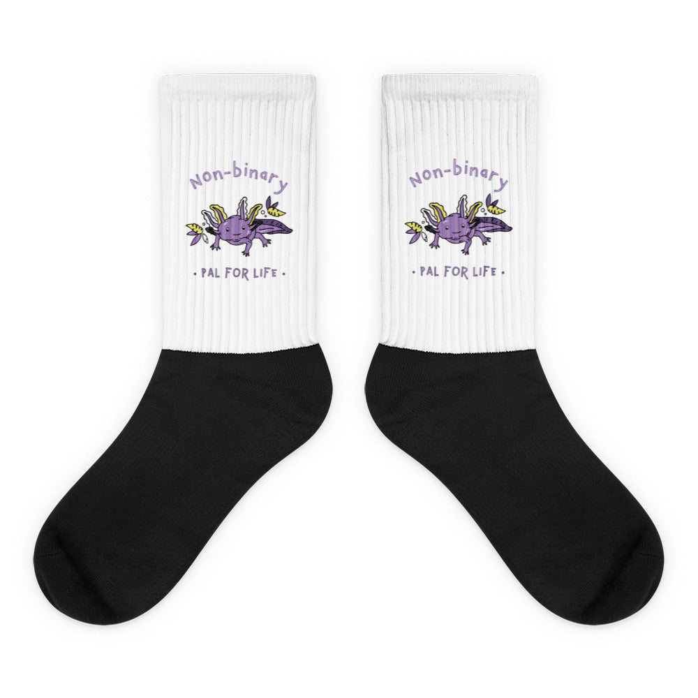 Pair of white and black socks with purple axolotls and “Non-binary Pal for Life” text