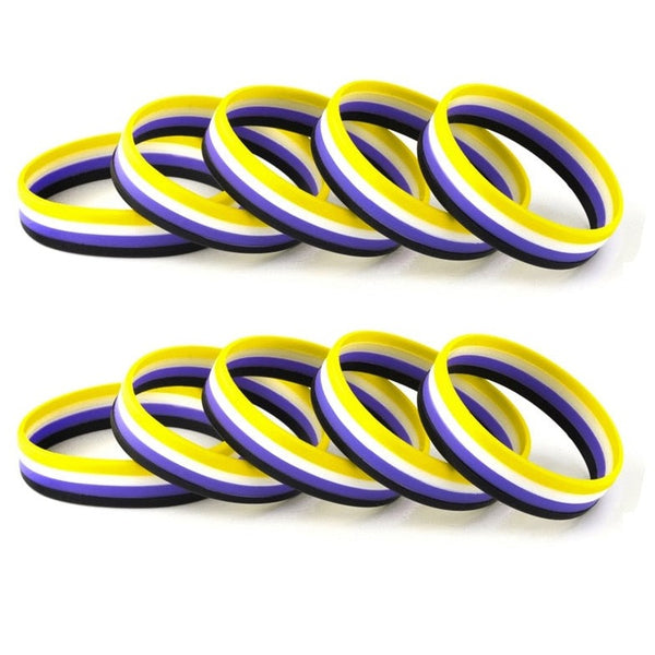 Two rows of black, purple, white, and yellow rubber wristbands arranged on a white background