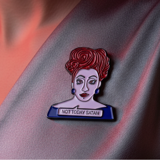 Not Today Satan Enamel Pin on grayish-lavender fabric depicts a fierce female bust with red hair and bold makeup