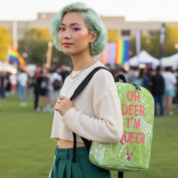 Person wearing a leafy green backpack reading “OH DEER I’M QUEER” at a Pride event