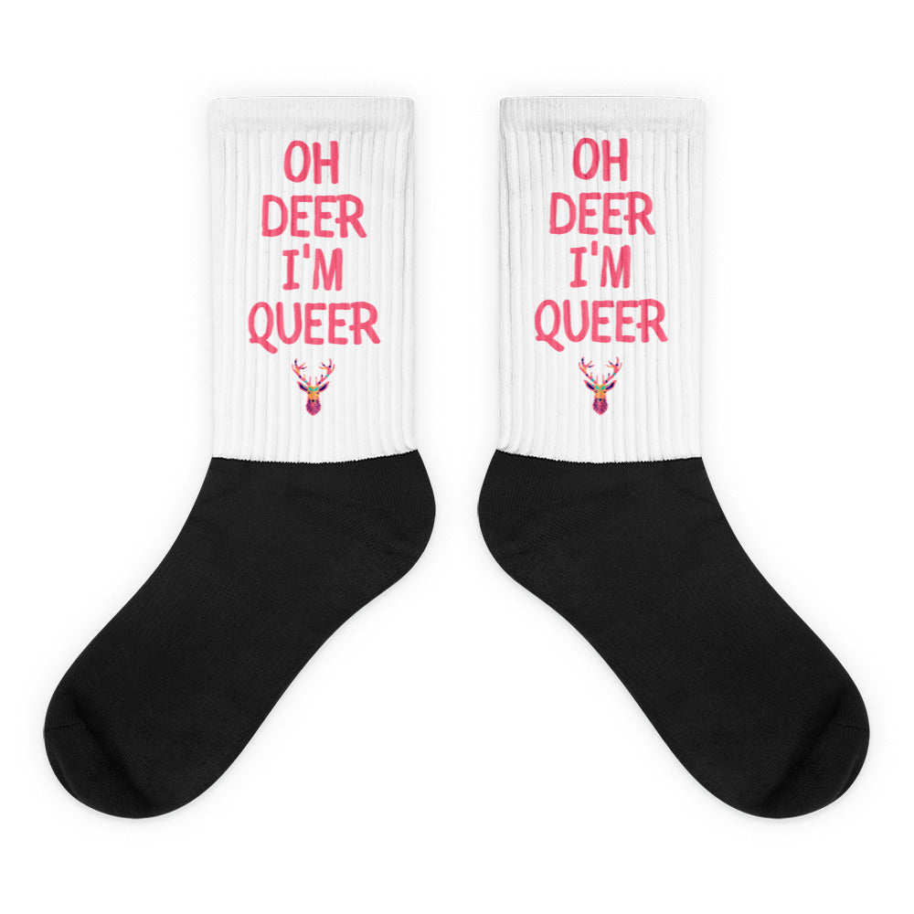 Pair of black-and-white socks reading “OH DEER I’M QUEER” with colorful deer graphics