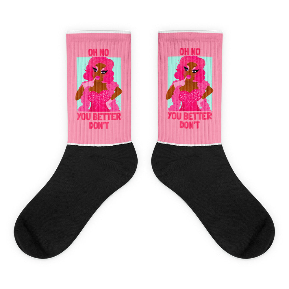 Pair of black crew socks with pink cuffs, a pink-haired figure, and “OH NO YOU BETTER DON’T” text