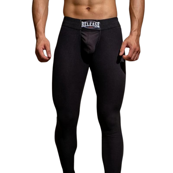 Front view of a model wearing black thermal assless chaps with a RELEASE waistband label