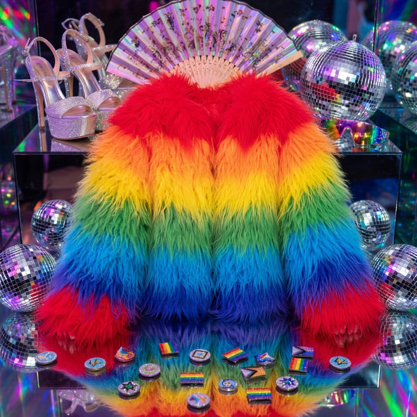 Front view of a vivid rainbow-striped shaggy faux-fur coat on a mirrored display