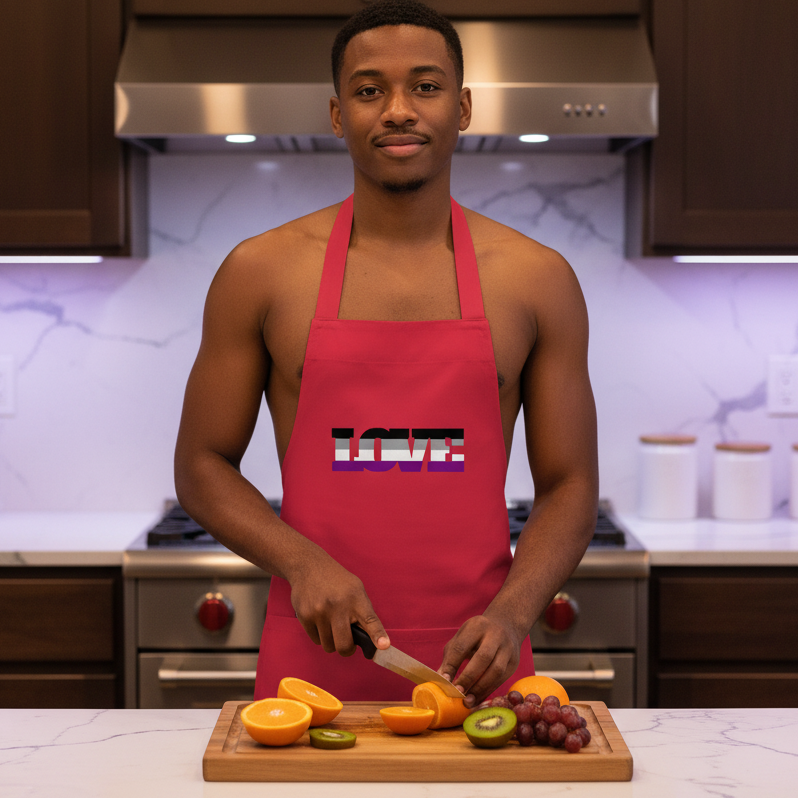 Young man in a modern kitchen wears an Asexual Love Organic Cotton Apron, slicing fruit. This stylish apron embodies queer pride, confidence, and self-expression, perfect for protecting clothes and adding flair.