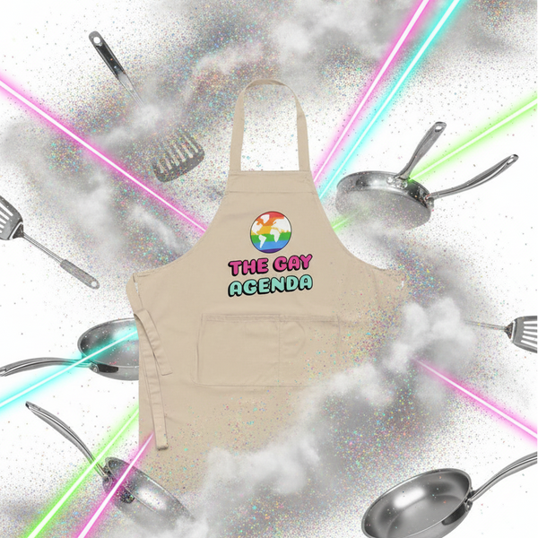The Gay Agenda Organic Cotton Apron with rainbow globe icon floats amid sparkly mist, surrounded by cookware and vibrant laser beams, embodying queer pride, empowerment, and a playful, confident kitchen vibe.