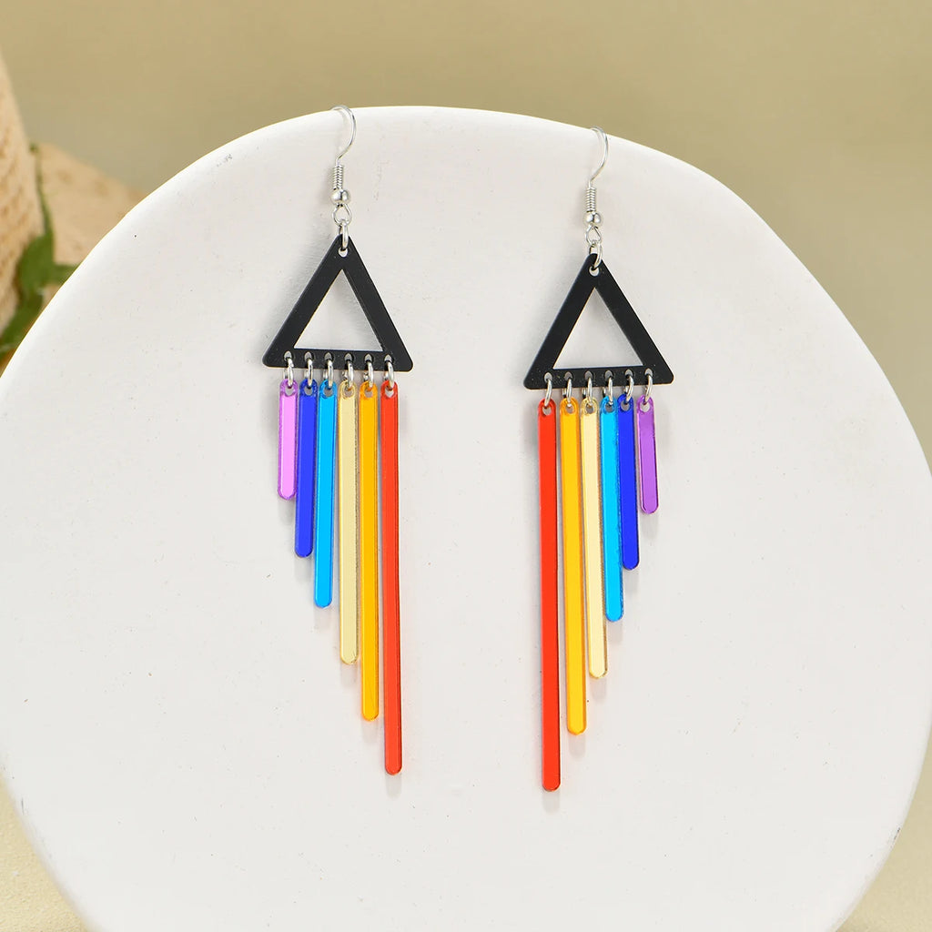 Pair of black triangle earrings with dangling rainbow-colored bars, shown on a white display