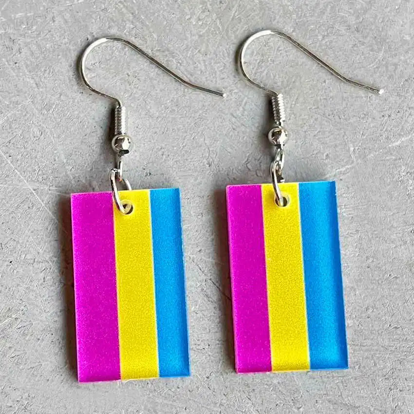 Pair of rectangular pink, yellow, and blue striped acrylic dangle earrings on a gray surface