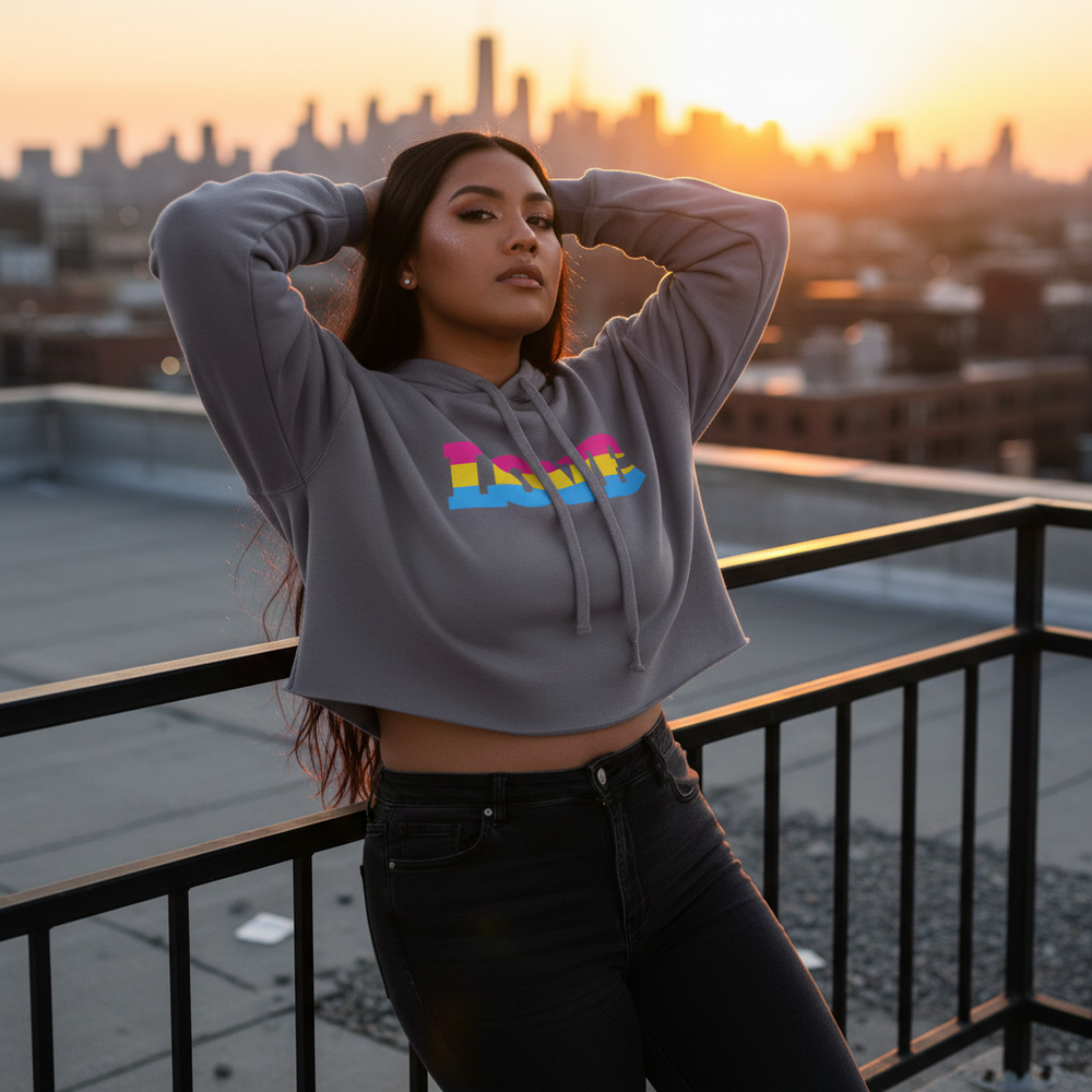 Pansexual Love Crop Hoodie with vibrant lettering is worn by a person on an urban rooftop at sunset