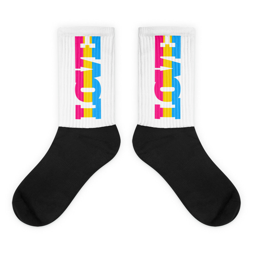 Pair of crew socks with black feet and white cuffs reading LOVE in pink, yellow, and blue