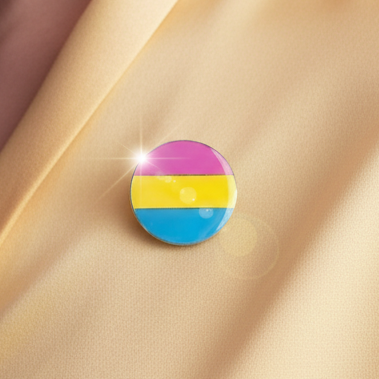 Pansexual pride enamel pin with pink, yellow and blue horizontal stripes on beige fabric