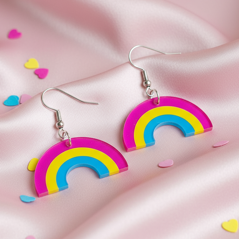 Pair of rainbow arch acrylic dangle earrings on pink satin