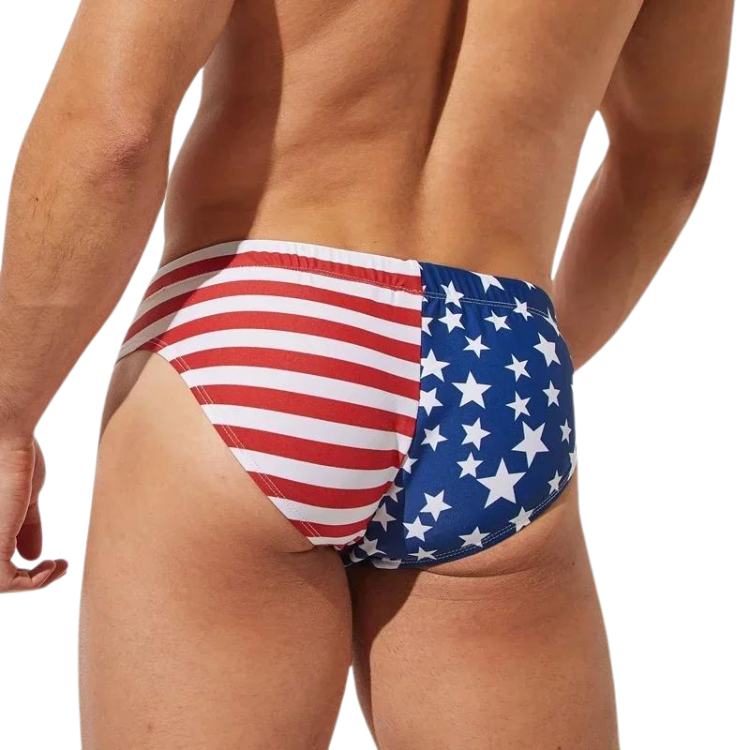 Rear view of a shirtless model wearing red, white, and blue American flag swim briefs