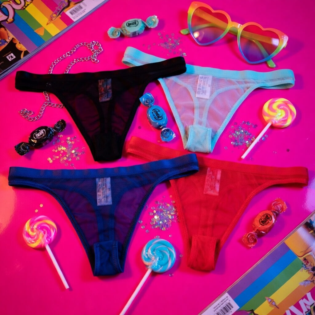 Flat lay of black, light blue, navy, and red sheer thongs on a pink background