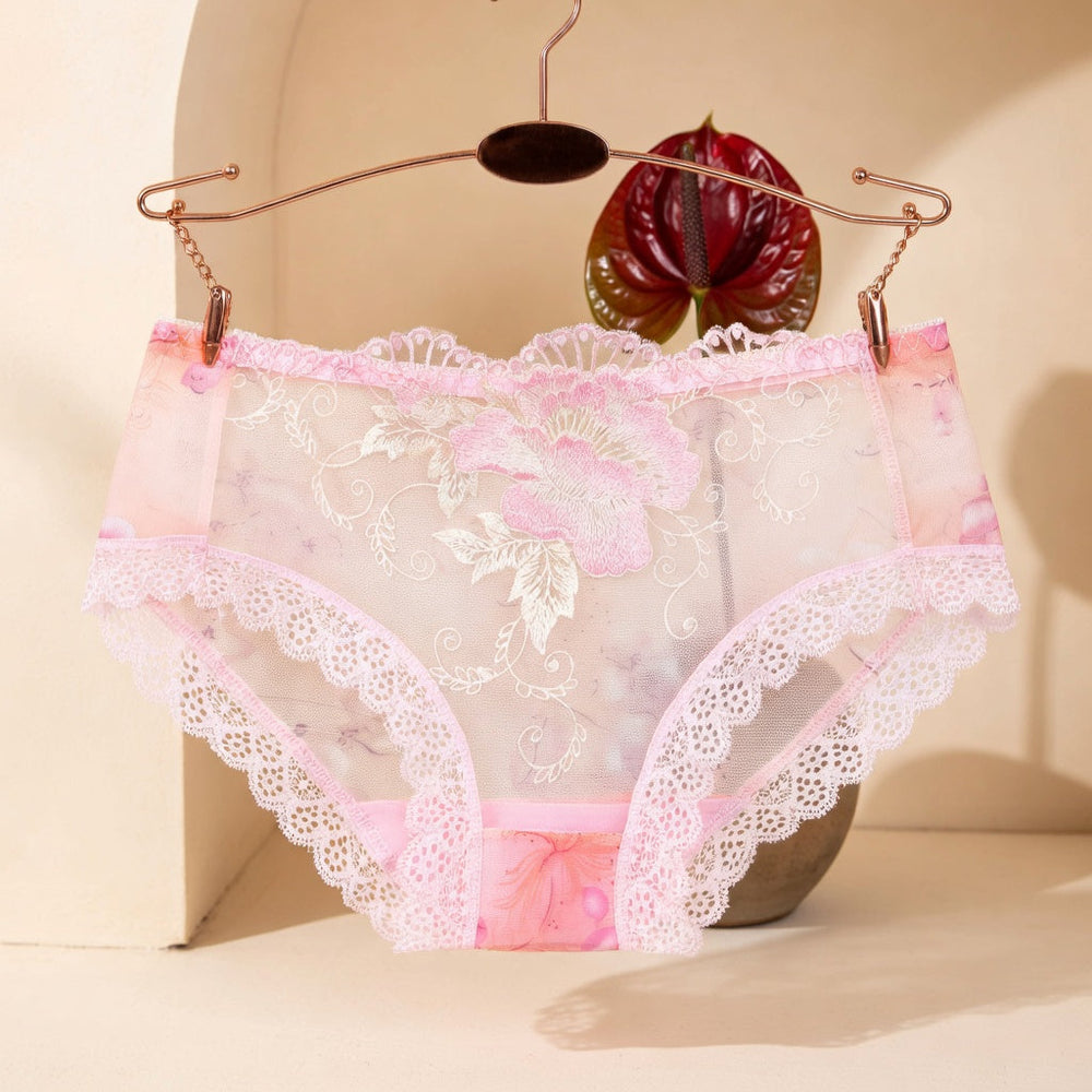 Pink floral lace low-rise underwear hanging from a bronze hanger beside a burgundy anthurium.