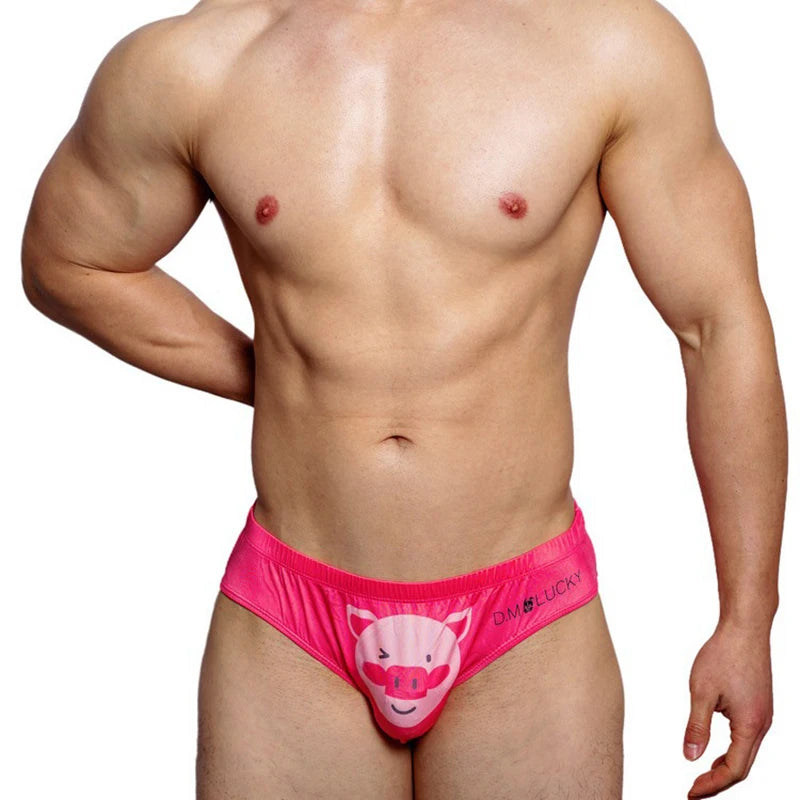 Front-facing shirtless model wearing bright pink brief underwear with a cartoon pig pouch