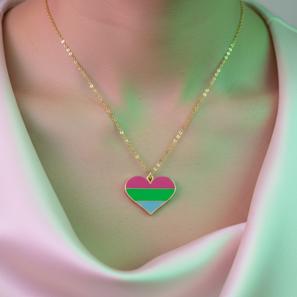 Gold-tone chain with a heart pendant featuring magenta, green, and blue stripes on a person's chest
