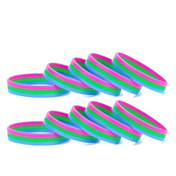 Stack of neon pink, green, and blue rubber wristbands arranged on a white background