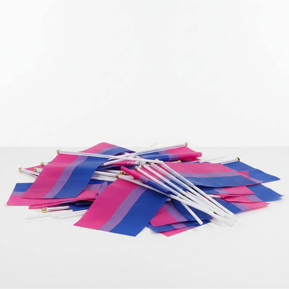 Close-up of several hand-held bisexual pride flags with pink, purple, and blue stripes