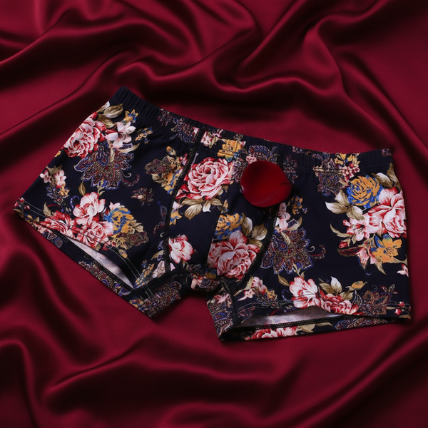 Close-up of dark floral-print boxers with a button fly on burgundy satin