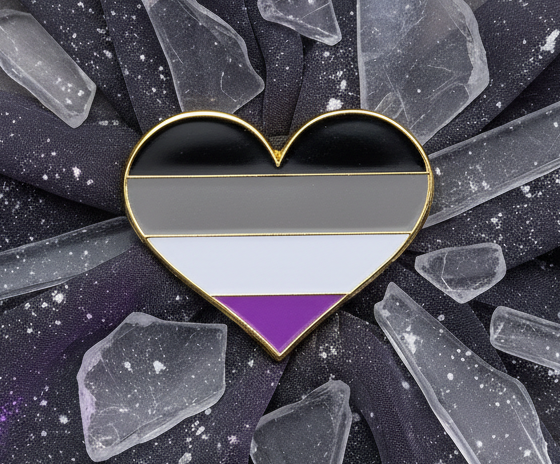 Asexual Pride Heart Enamel Pin on starry fabric, featuring bold black, gray, white, and purple stripes. Clear crystal shards surround the pin, embodying fierce queer pride and self-expression.