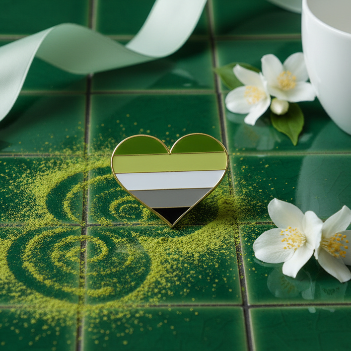 Aromantic pride heart enamel pin with green, white, gray, and black stripes on green tile