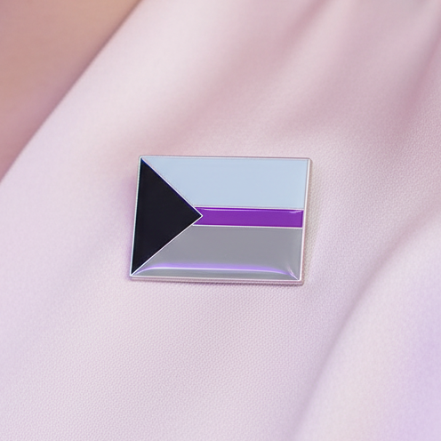 Demisexual Flag Enamel Pin on pink fabric, featuring black, light gray, purple, and darker gray stripes. Celebrate asexual pride with this bold accessory, empowering visibility and self-expression.