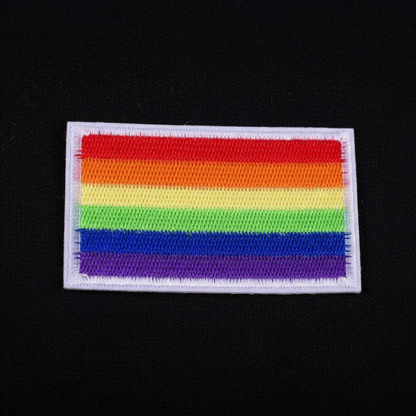 Rectangular embroidered LGBT rainbow pride flag iron-on patch on black fabric