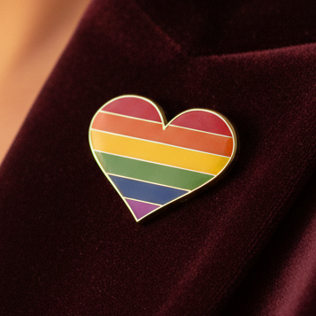 Lesbian pride heart enamel pin with horizontal rainbow stripes on burgundy fabric