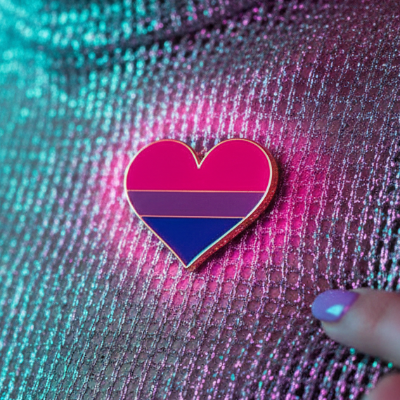Bisexual pride heart enamel pin with pink, purple, and blue stripes on shimmering fabric