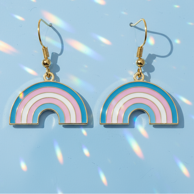 Gold-tone trans pride rainbow dangle earrings with pink, white, and blue enamel arches