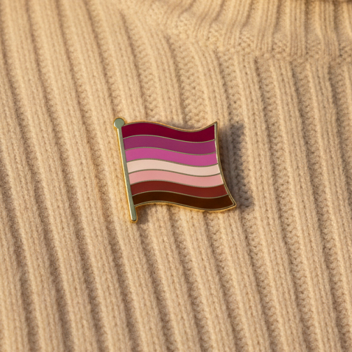 Lesbian pride flag enamel pin on a ribbed beige fabric surface