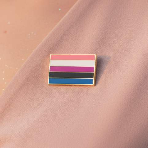 Genderfluid Pride Enamel Pin, small and vibrant, rests on pink fabric, showcasing bold stripes for genderfluid pride. Celebrate self-expression and empowerment with this dazzling, prideful accessory from Queer In The World.