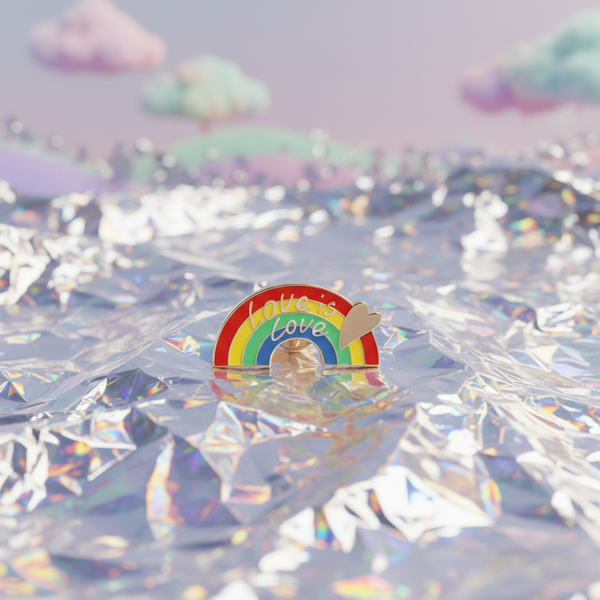Love Is Love Rainbow Enamel Pin featuring a vibrant rainbow and heart, set on holographic foil, symbolizes pride and self-expression. Perfect for celebrating LGBTQIA+ identity with visibility and empowerment.
