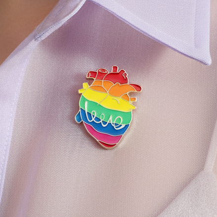Rainbow LGBT heart enamel pin attached to a white mesh garment