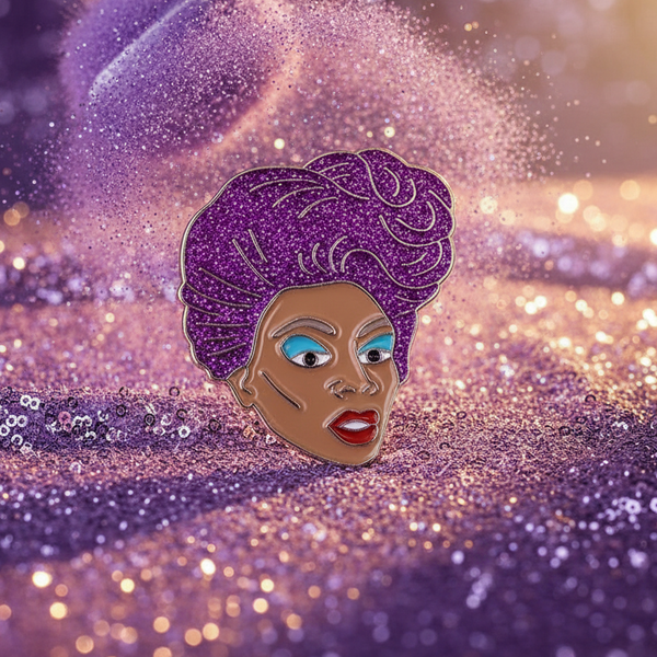 RuPaul enamel pin depicting a glamorous face with purple hair, blue eyes, and red lips