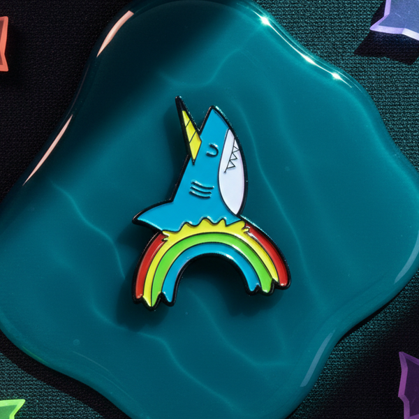 Rainbow shark enamel pin with a colorful rainbow tail on a teal background