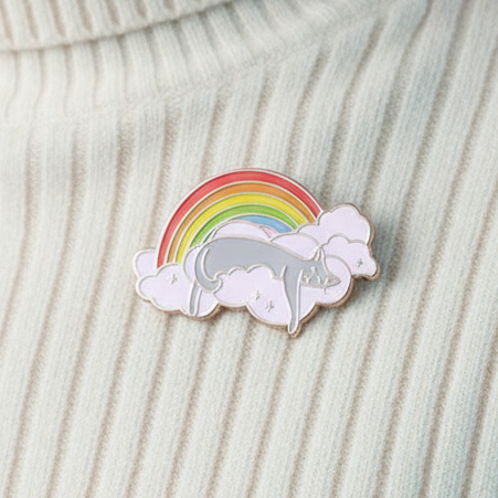 Rainbow cat resting on a cloud enamel pin with pastel rainbow stripes