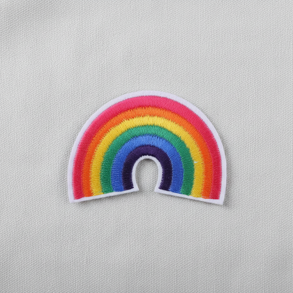 Close-up of a rainbow embroidered iron-on patch on white fabric