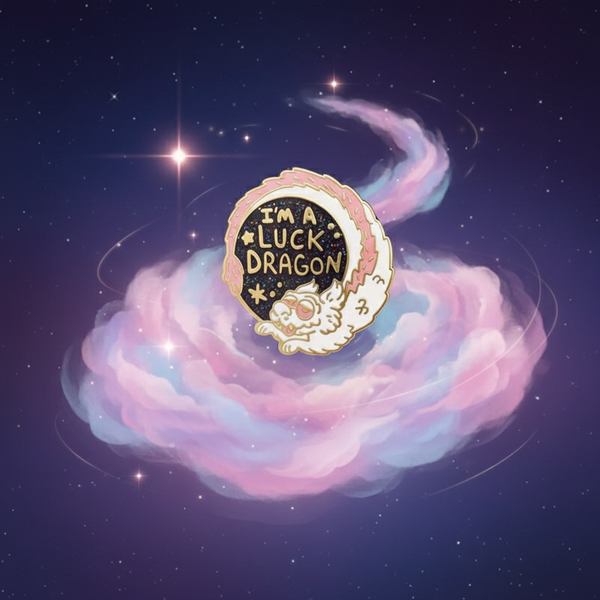 I'm A Luck Dragon Enamel Pin: A gold-trimmed badge with I’M A LUCK DRAGON text, featuring a white serpentine dragon. Celebrate queer pride and self-expression with this empowering accessory from Queer In The World.