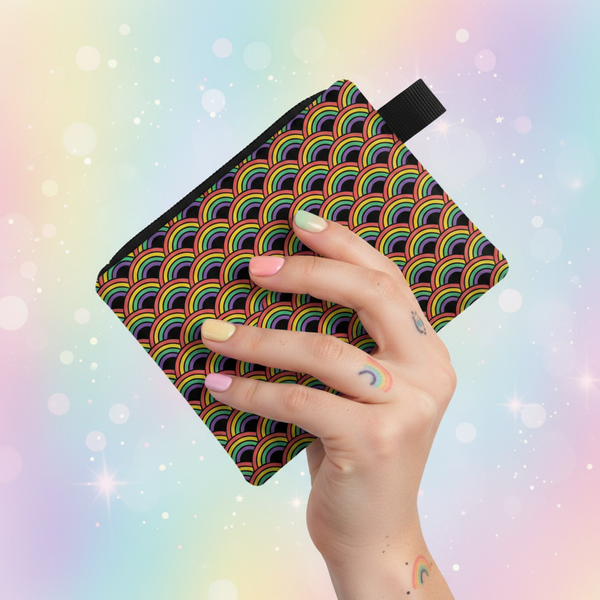 Hand holding a rainbow-patterned coin purse with a black wrist strap