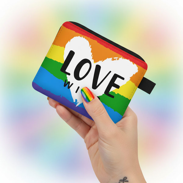 Hand holding a rainbow-striped Love coin purse with a black zipper