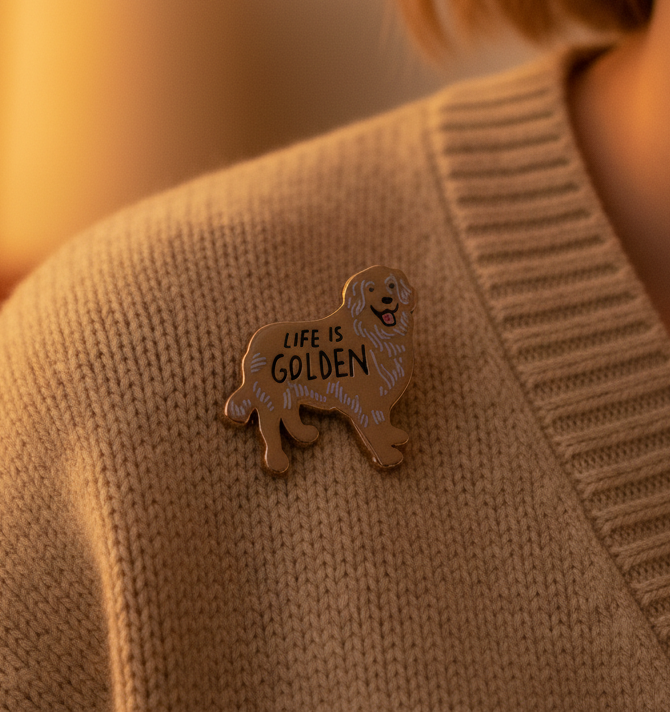 Golden dog enamel pin reading “LIFE IS GOLDEN” on a knit sweater