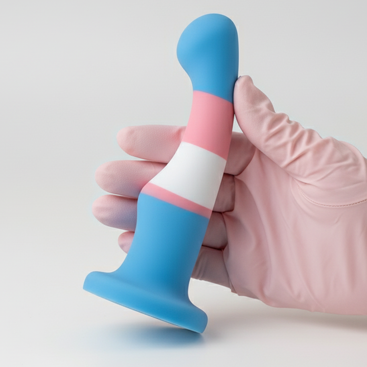 Close-up of a blue, pink, and white transgender pride silicone dildo held in a pink glove