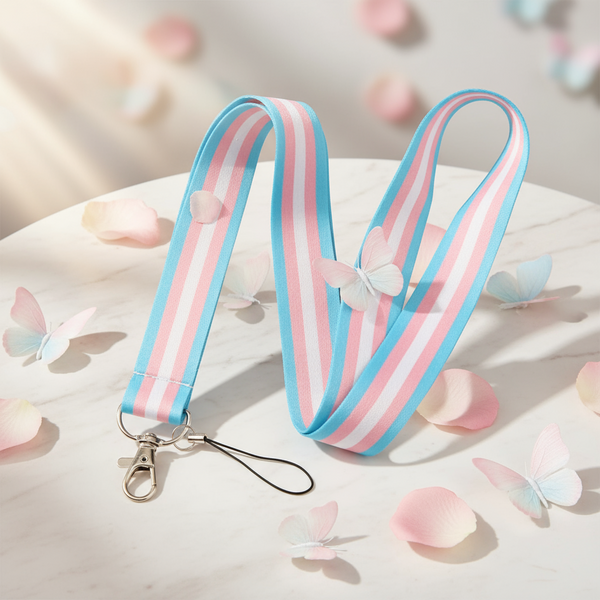 Trans pride lanyard with pastel blue, pink, and white stripes, clasp, and wrist loop on a marble surface